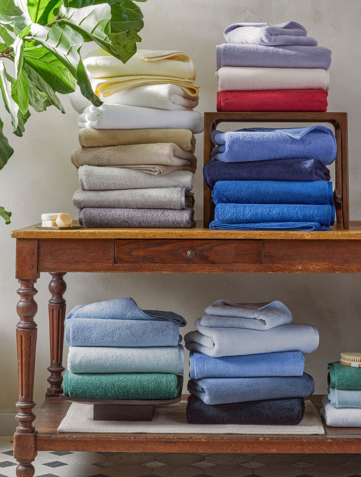 Matouk Milagro towels in assorted colors displayed on a wooden table